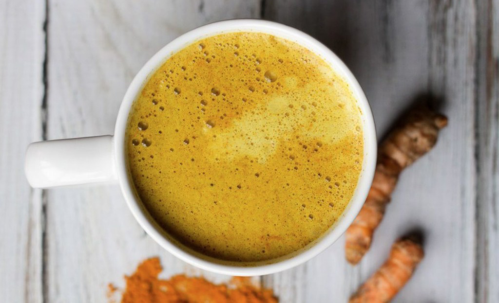 Taza de leche dorada con canela y cúrcuma